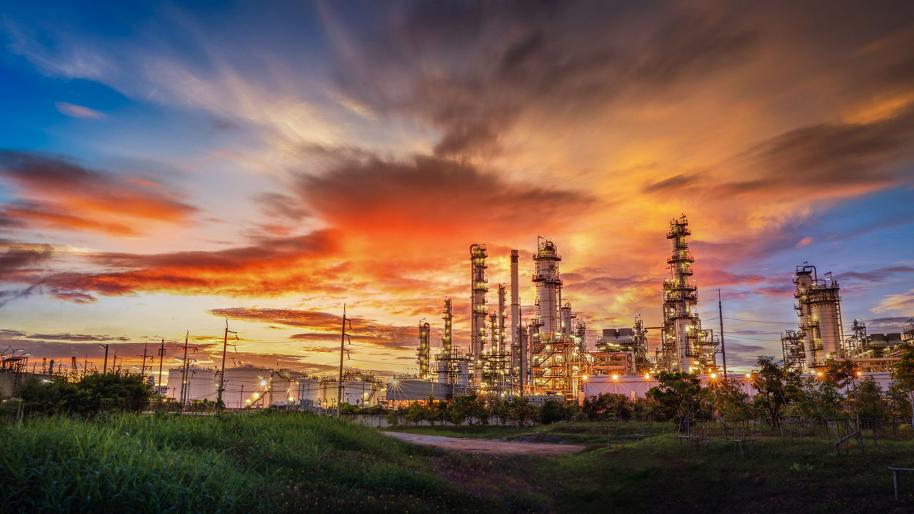 Chemical oil refinery plant, Power plant and metal pipe on red sunrise sky background.