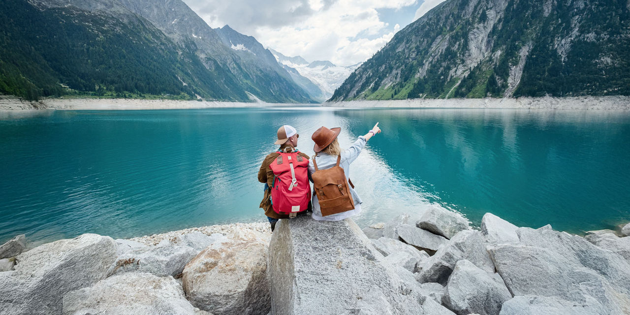 Young couple looking afar into the lake and mountain
