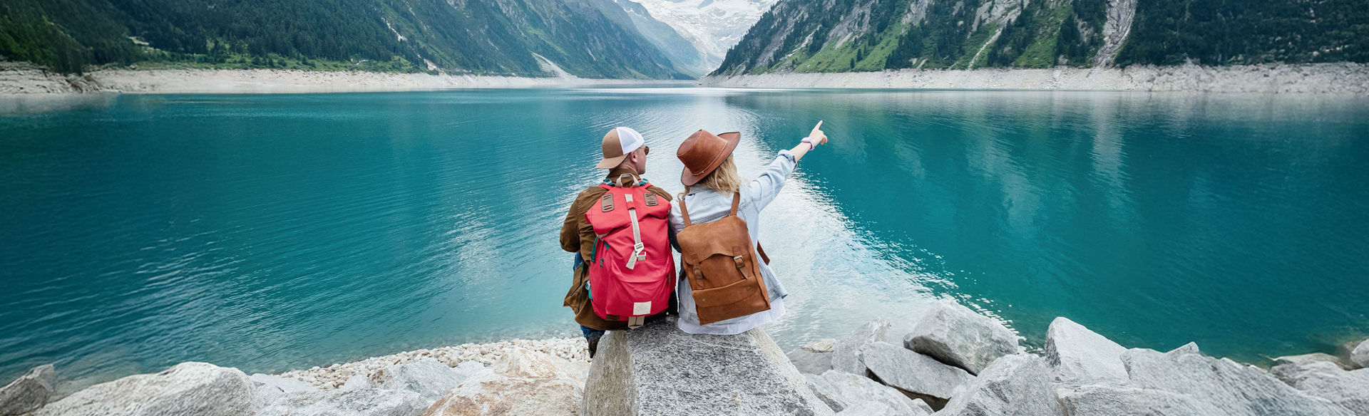 Young couple looking afar into the lake and mountain